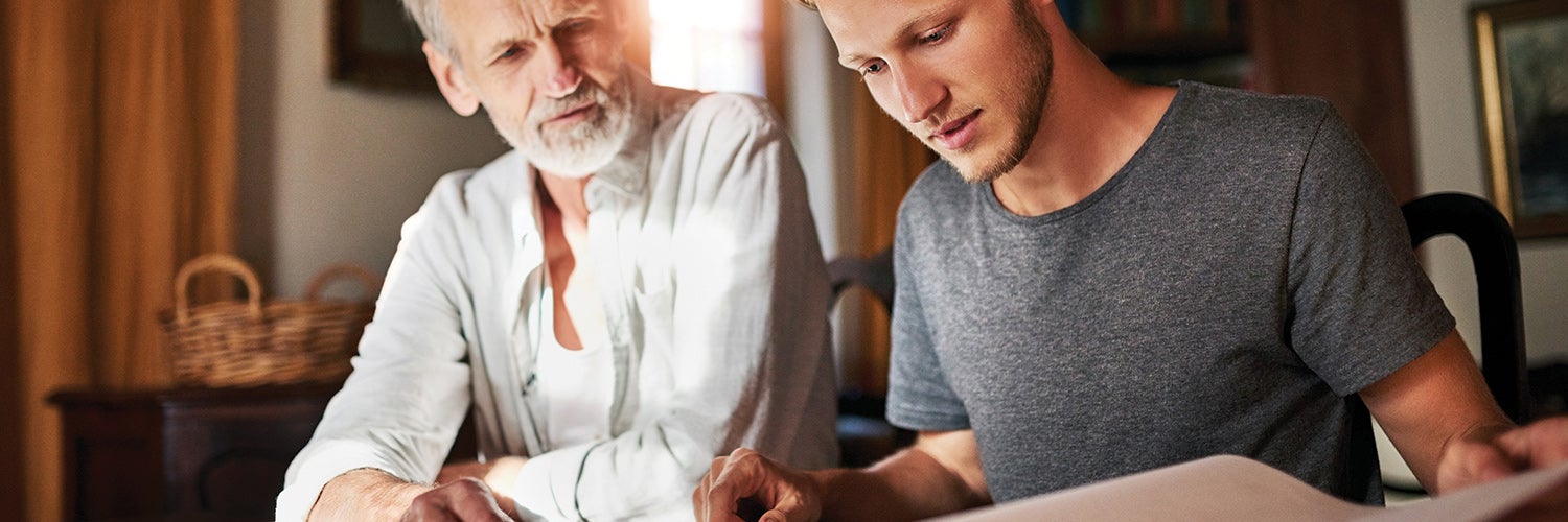 Father and son looking over paperwork together