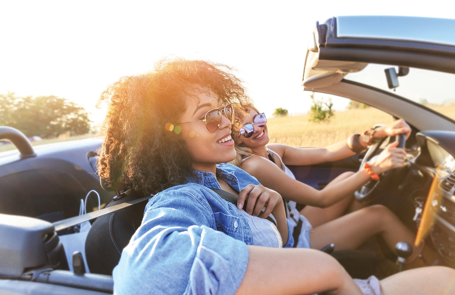 Two women driving in a recently purchased car.