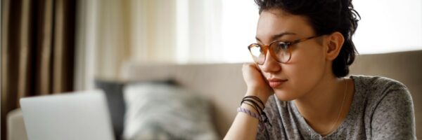 chica con gafas mirando portátil