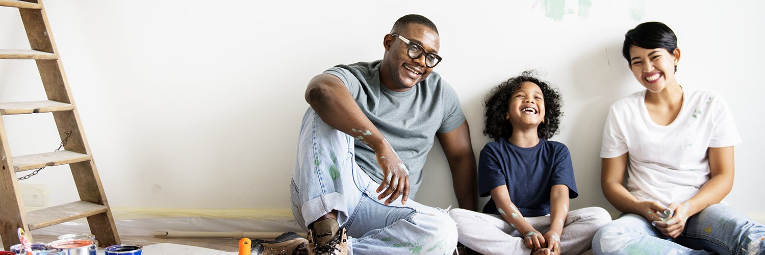 A family sits in front of a recently painted wall.