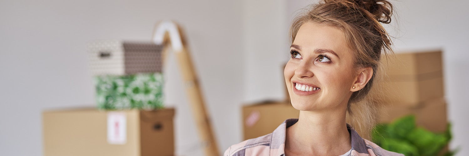 A woman in her new home smiles.