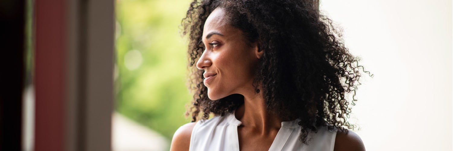 woman smiling and looking through window