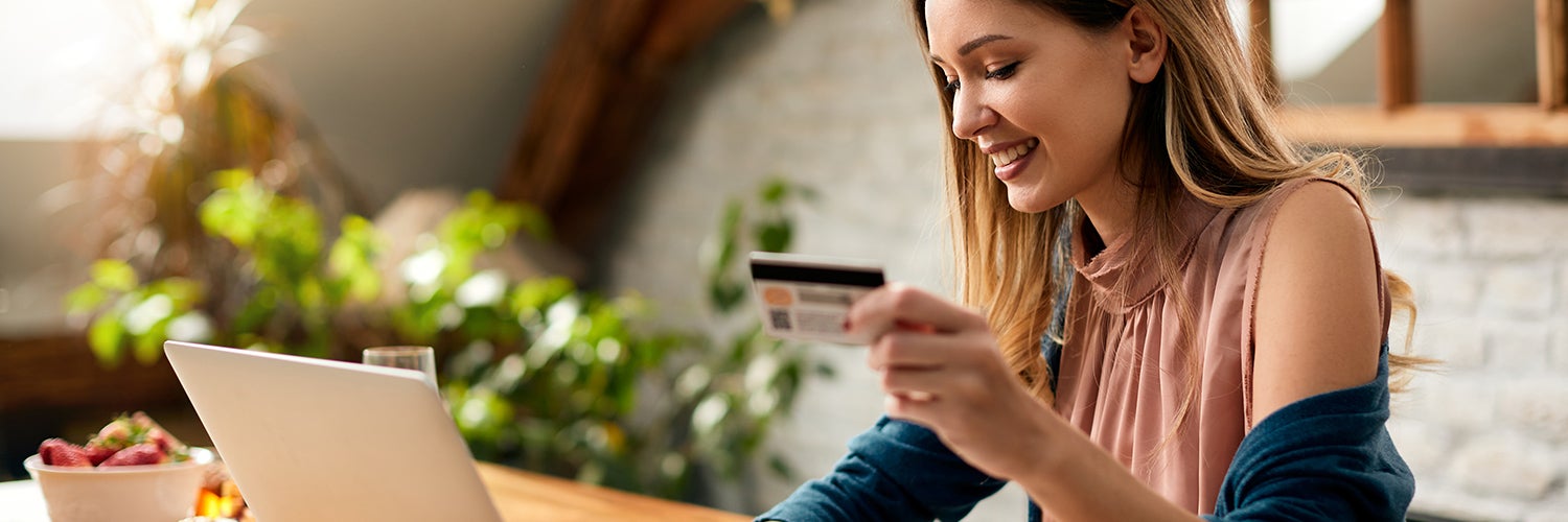 How long do negative items stay on credit reports? Woman with credit card looks at computer.