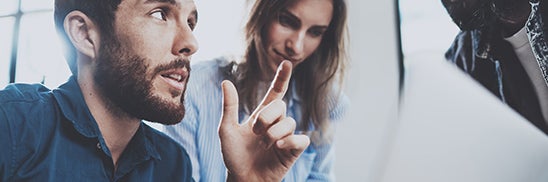 man and woman talk about something written on paper